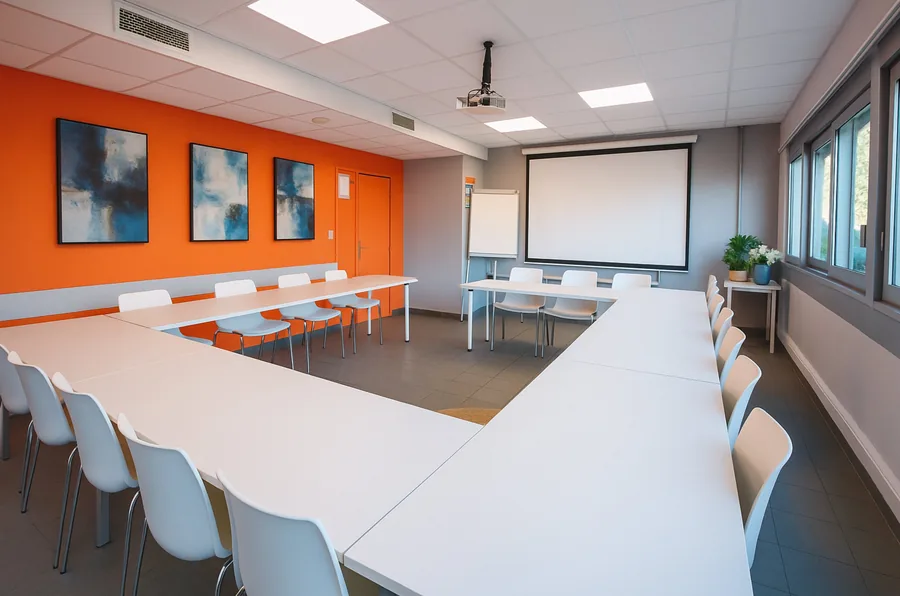 Salle Pic Saint-Loup grande — 25 personnes vidéoprojecteur écran blanc mur orange Millénaire Montpellier formation